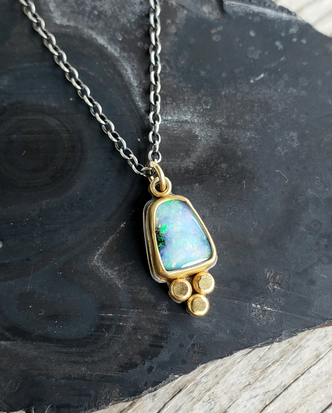 Natural, flashy boulder opal in 22k gold and silver
